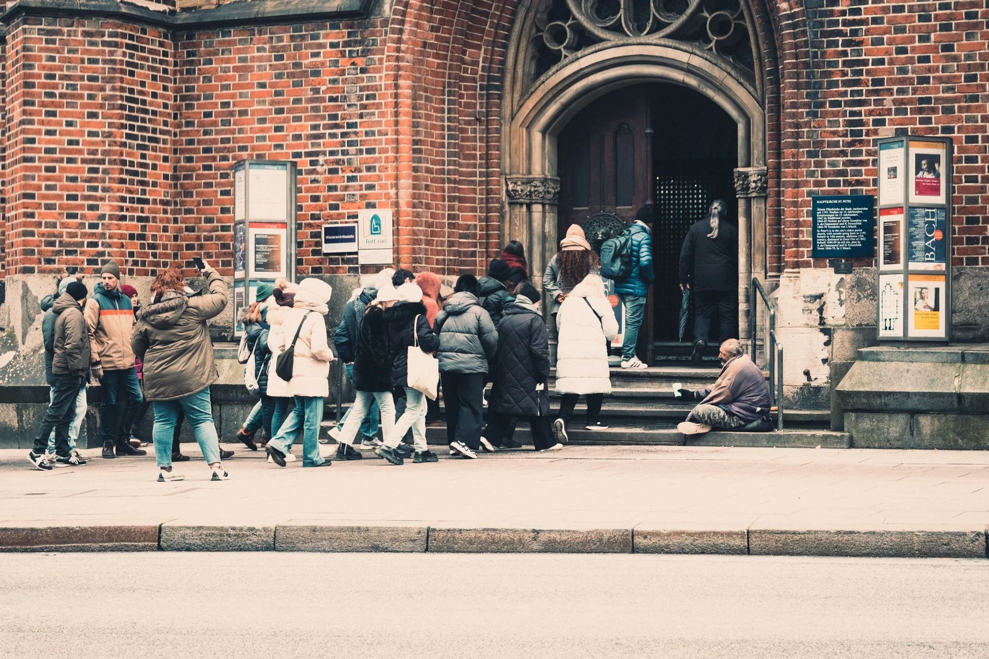 bettelnder Mensch vor Kirche